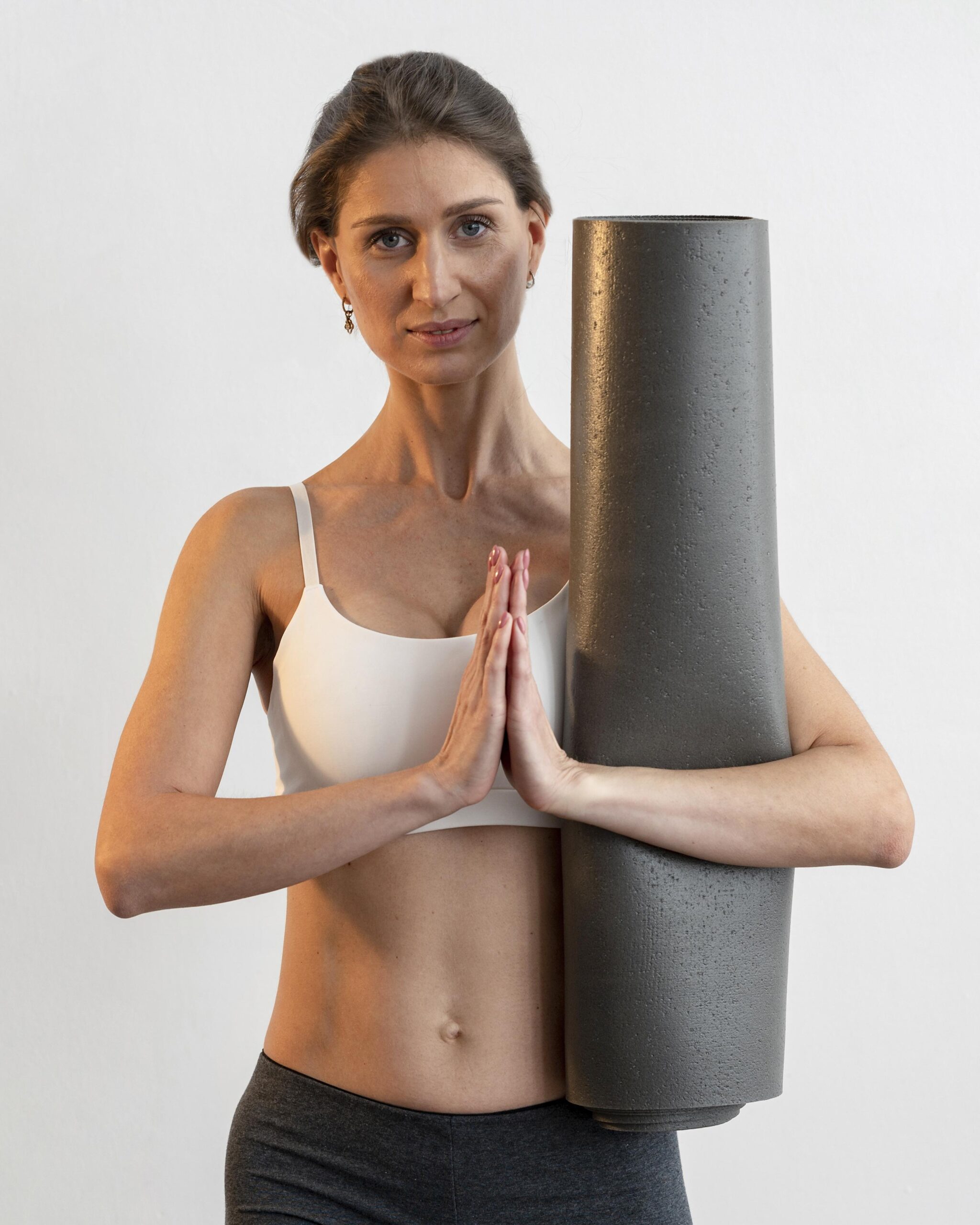 front-view-woman-holding-yoga-mat-while-doing-pose